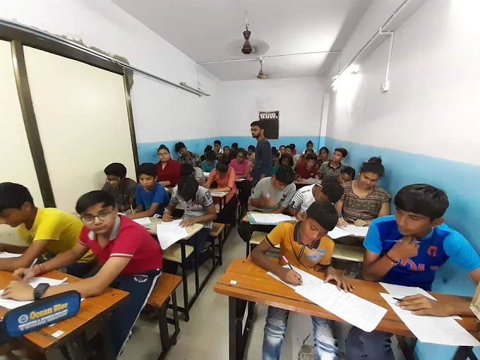 Students writing during a classroom session at Ocean Blue Spoken English, Vastral